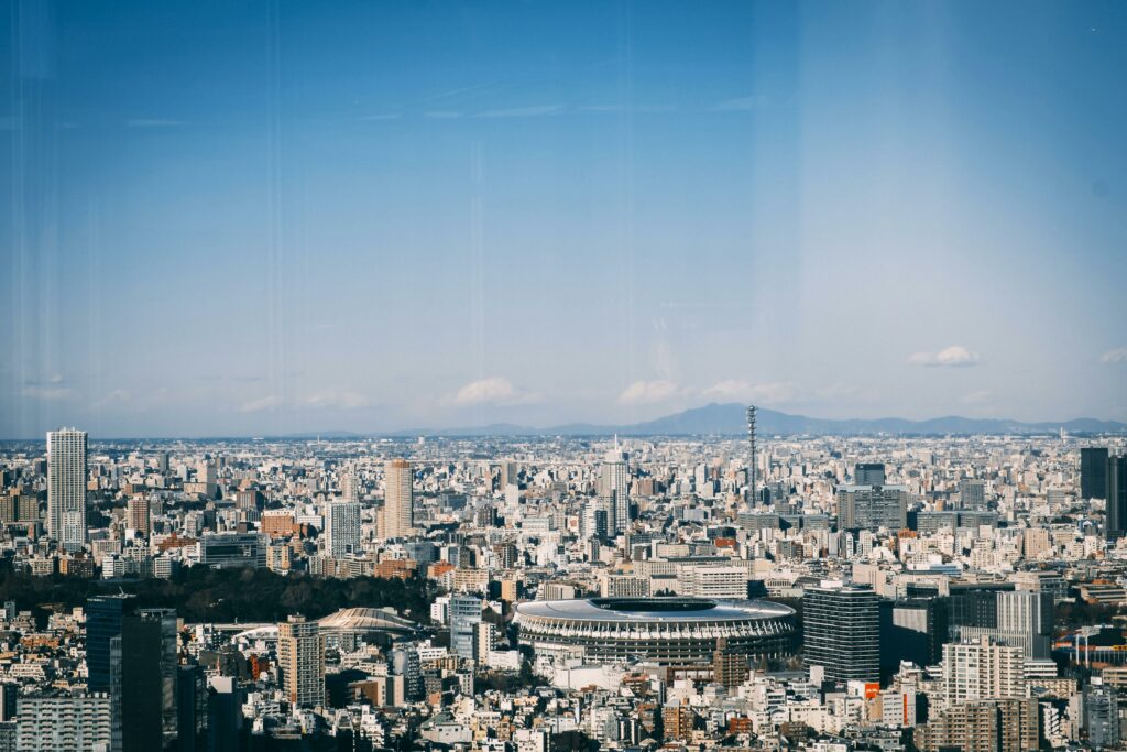 An awe-inspiring view of Tokyo cityscape featuring the New National Stadium under a clear blue sky.
